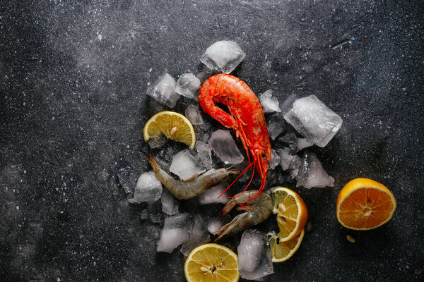 shrimp in ice with lemon on a gray background