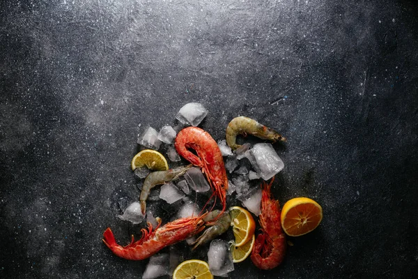 Buzlu karides, gri arka planda limon.