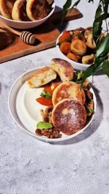 Beyaz tabakta kurutulmuş meyveli iştah açıcı peynirli kekler.