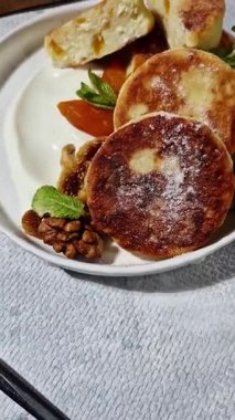 Beyaz tabakta kurutulmuş meyveli iştah açıcı peynirli kekler.