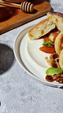 Beyaz tabakta kurutulmuş meyveli iştah açıcı peynirli kekler.