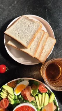 Beyaz tabakta alabalık, havyar, avokado, yumurta ve kırmızı havyar.