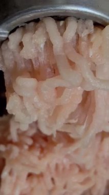 Taze tavuk etinin metal kıyma makinesinde öğütüldüğü makro video. Çiğ kümes hayvanları kıyma haline getiriliyor..