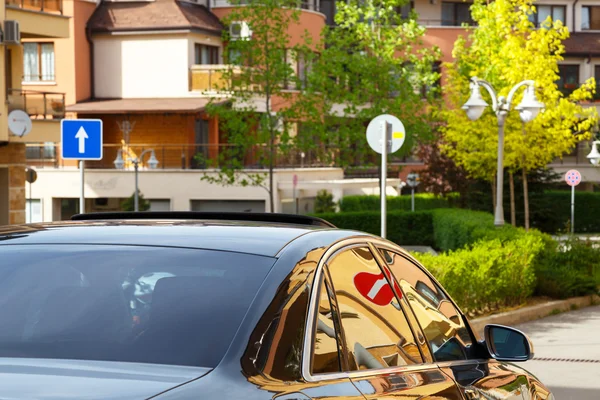 Car with dark tinted windows driving down a street Royalty Free Stock Images