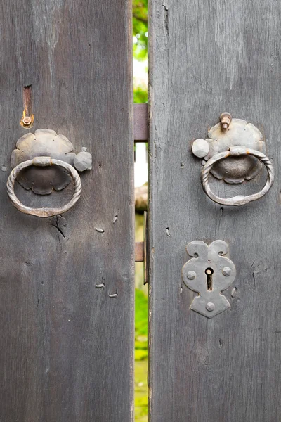 Two old iron ring handles on a door standing ajar — Stock Photo, Image