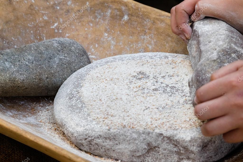 Making flour in a traditional way for the Neolithic era Stock Photo by