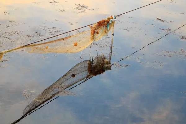 Lege fishnet voor mosselconserven in de zee bij zonsondergang — Stockfoto