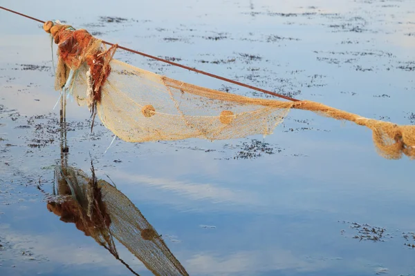 Lege fishnet voor mosselconserven in de zee bij zonsondergang — Stockfoto