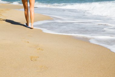 Kumsalda yürüyen bir kadın