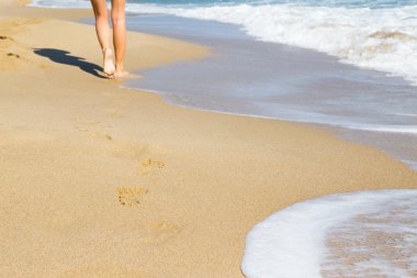 Kumsalda yürüyen bir kadın