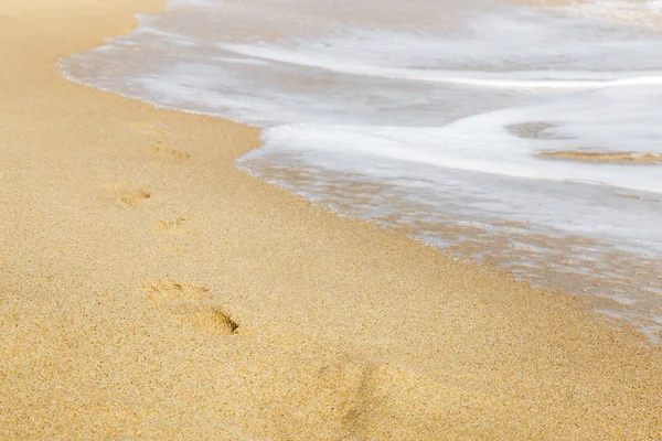 Fußabdrücke im goldenen Sand — Stockfoto