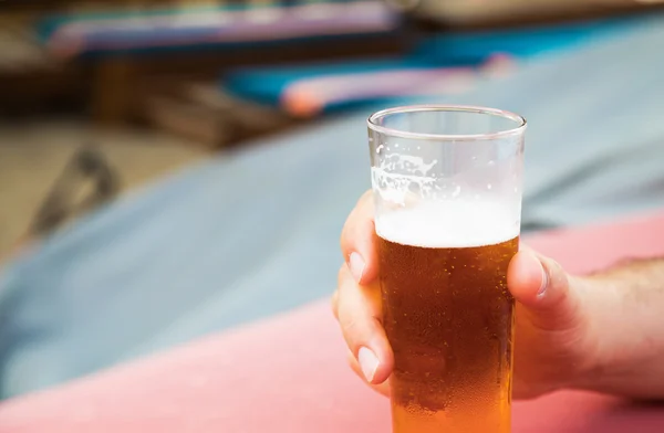Male hand holding a glass of cold beer Royalty Free Stock Photos