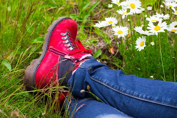 Bir çayır üzerinde döşeme kırmızı hiking giyen kadın çizme