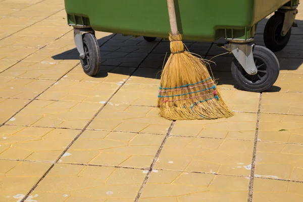 Part of a modern plastic bin with an old straw broom — Stock Photo, Image