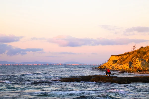 Lone fisherman fishing off rocks — Stock Photo, Image