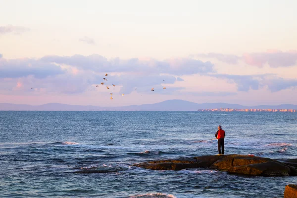 Yalnız balıkçı kayalardan balıkçılık — Stok fotoğraf