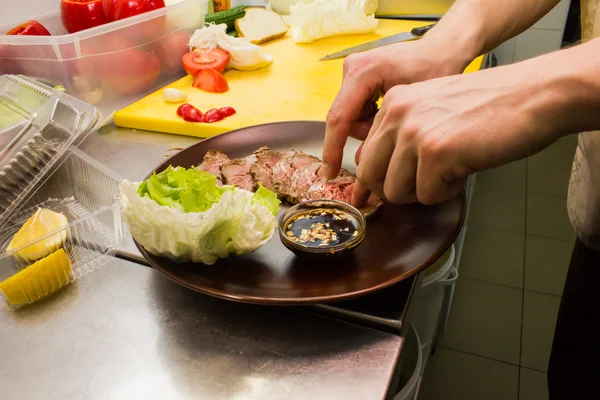 The chef serves the dish on the plate — Stock Photo, Image