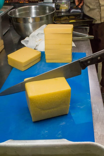 The chef cuts the cheese in the kitchen — Stock Photo, Image