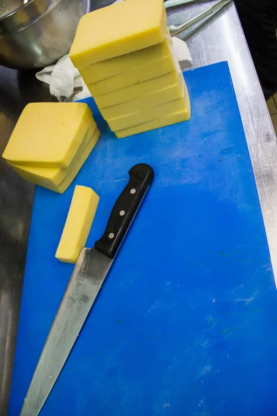 El chef corta el queso en la cocina — Foto de Stock