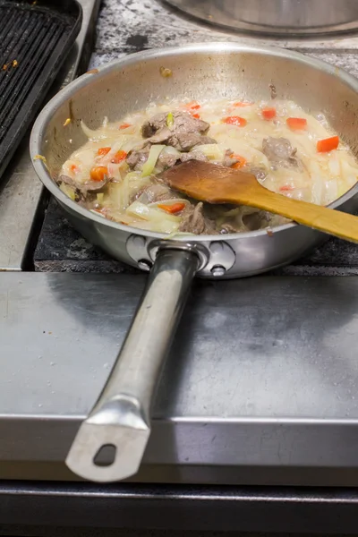 Le chef cuisine la viande dans la casserole — Photo