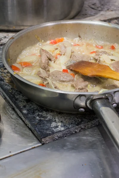 Le chef cuisine la viande dans la casserole — Photo