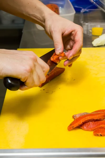 Chef memotong ikan merah di dapur — Stok Foto