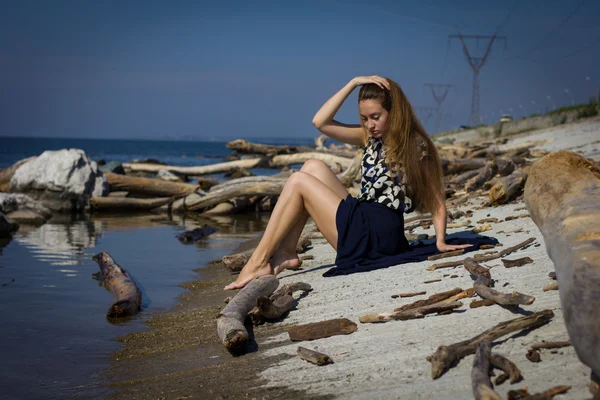 Fille sur la plage aux bûches — Photo