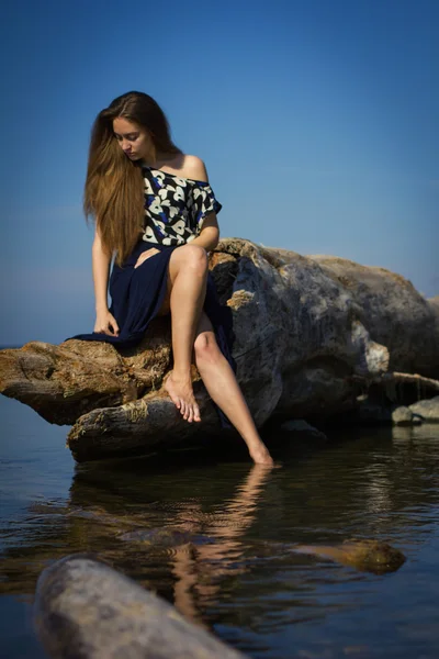 Flicka på stranden i loggarna — Stockfoto