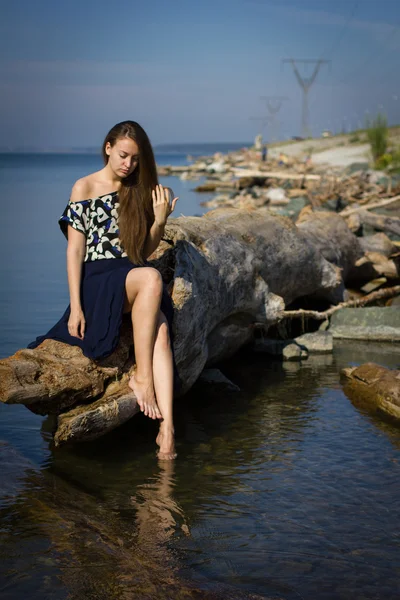 Mädchen am Strand bei den Baumstämmen — Stockfoto