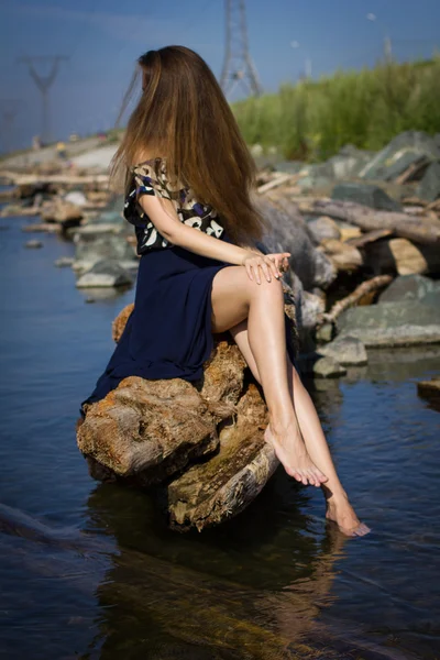 Girl on the beach at the logs — Stock Photo, Image