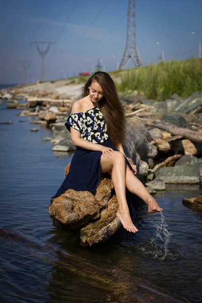 Mädchen am Strand bei den Baumstämmen — Stockfoto