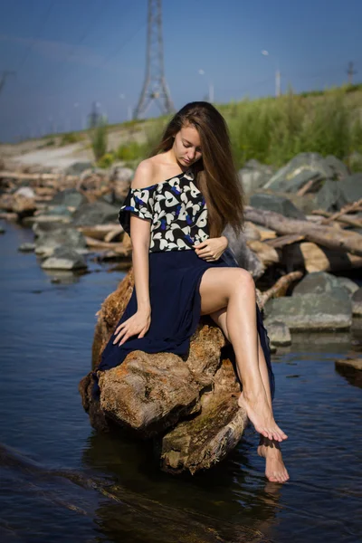 Mädchen am Strand bei den Baumstämmen — Stockfoto