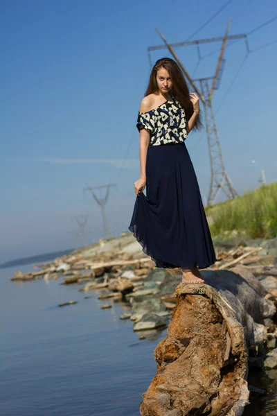 Girl on the beach at the logs — Stock Photo, Image