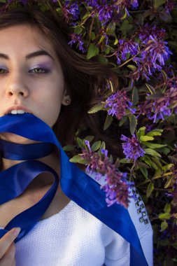 bir çiçek çayır üzerinde yatan bir kız portresi