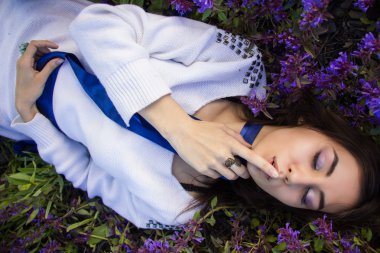 bir çiçek çayır üzerinde yatan bir kız portresi