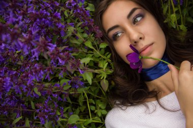 bir çiçek çayır üzerinde yatan bir kız portresi