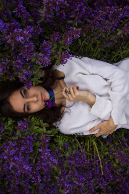 portrait of a girl lying on a flower meadow clipart