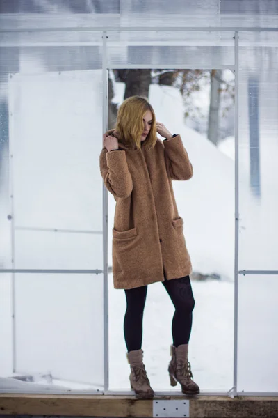 The girl in the coat in the greenhouse — Stock Photo, Image