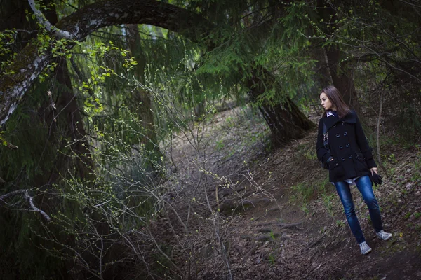 Dívka v kabátě v lese — Stock fotografie