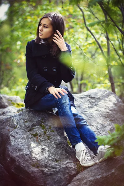 Menina bonito sentado em uma rocha — Fotografia de Stock