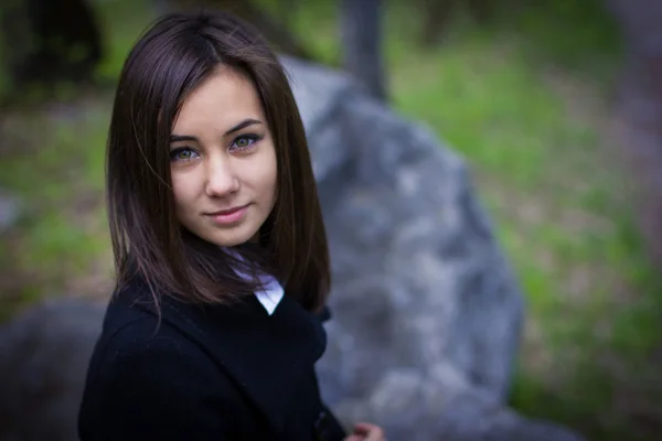 Menina bonito sentado em uma rocha — Fotografia de Stock