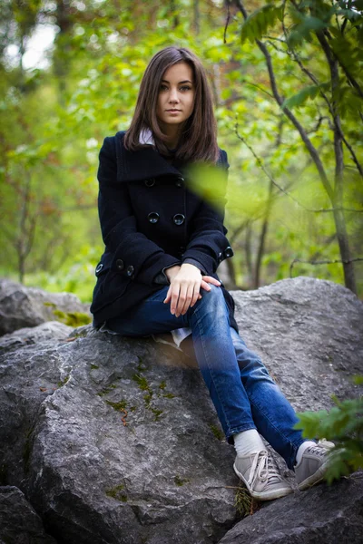 Linda chica sentada en una roca — Foto de Stock
