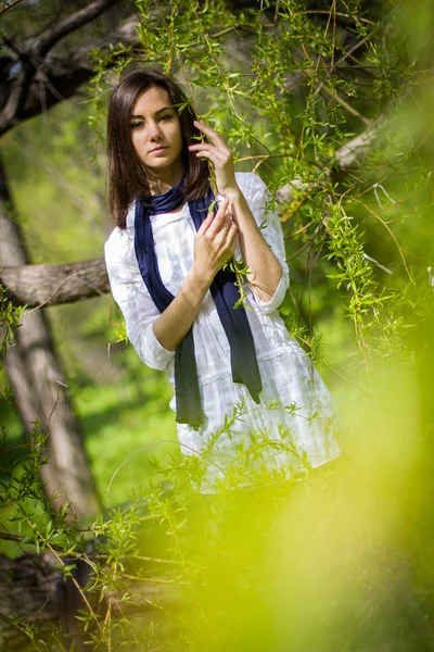 Menina bonita em uma árvore de floração — Fotografia de Stock