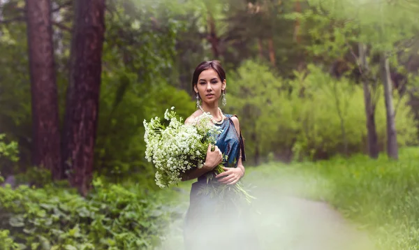 Dívka v šatech sbírá květiny — Stock fotografie