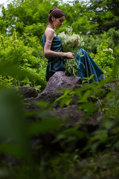 Fille en robe avec des fleurs dans la forêt — Photo