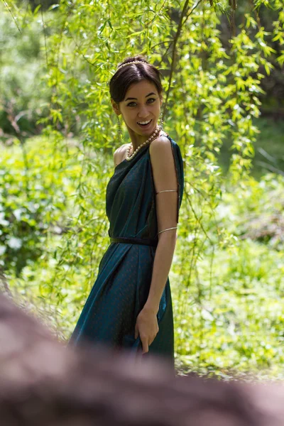 Fille en robe debout et souriant dans la forêt — Photo