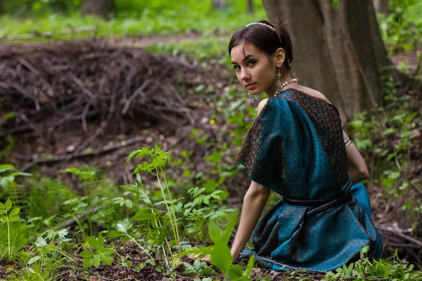 Menina de vestido sentado na floresta — Fotografia de Stock