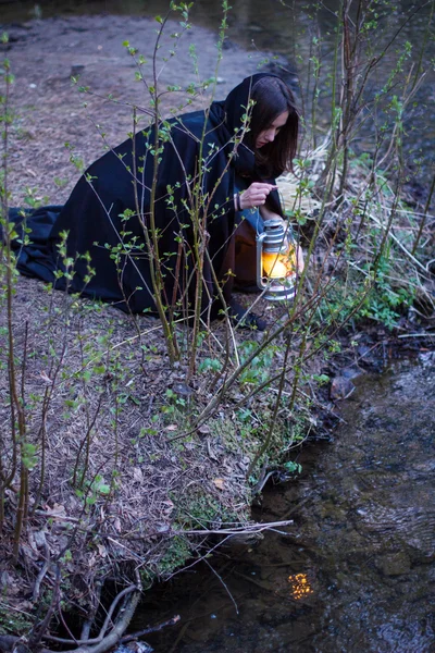 Girl with a lantern at the river — Stock Photo, Image