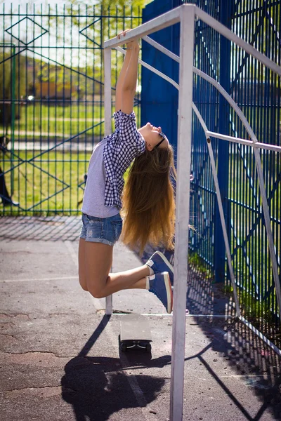 可爱的女孩在操场上滑板短裤 — 图库照片