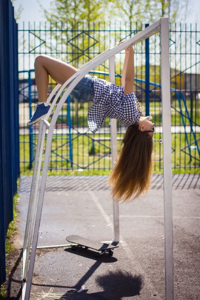 Cute girl in shorts with a skateboard on the Playground — Stock Photo, Image